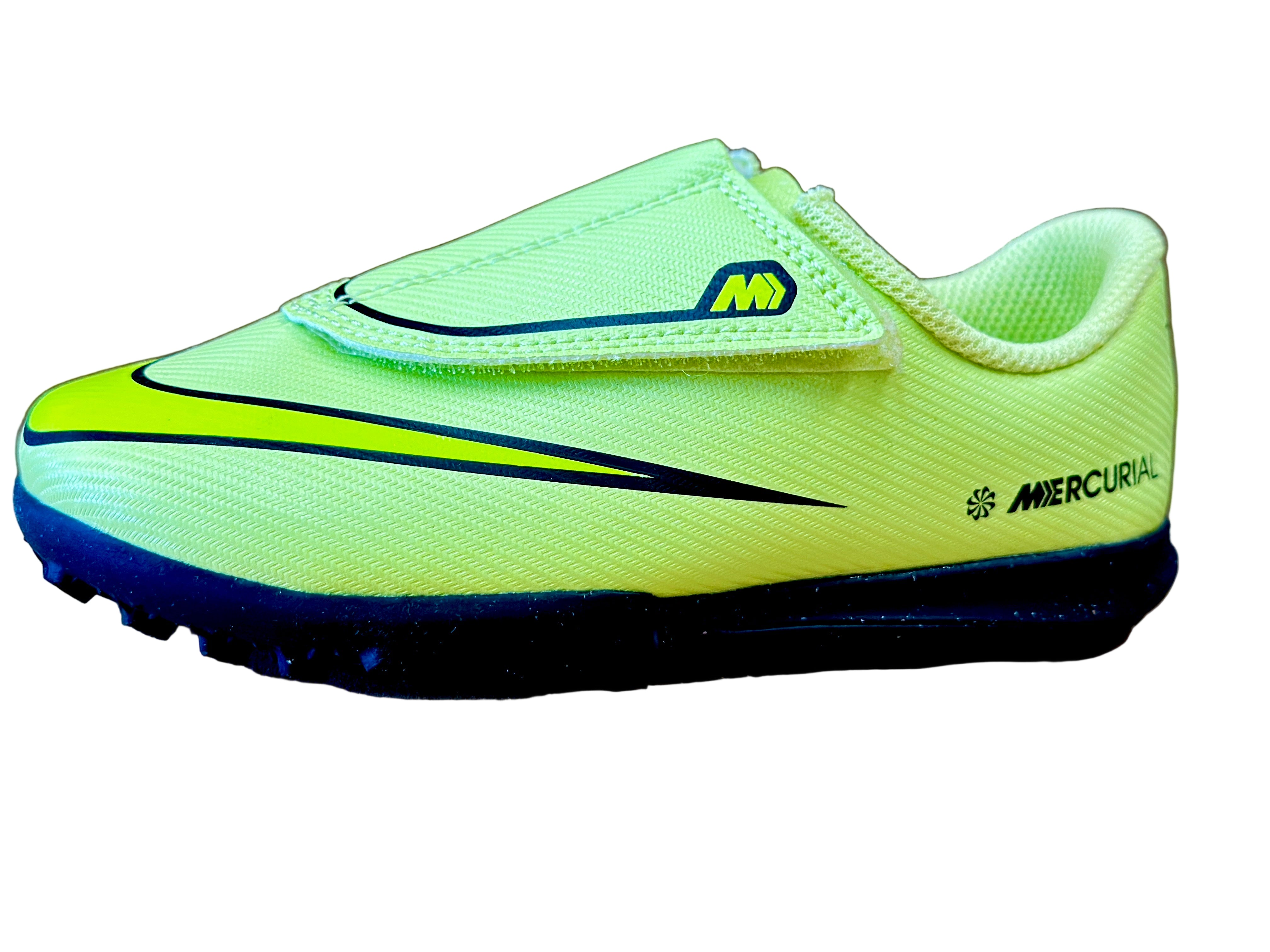 Bright green soccer shoe with black sole on a beige surface