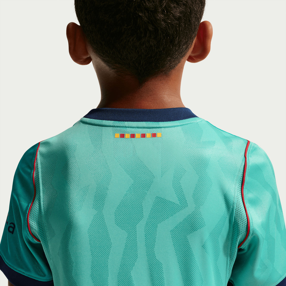 Coliseum Sports youth Barcelona 3rd stadium jersey in teal with red accents and back neck detail