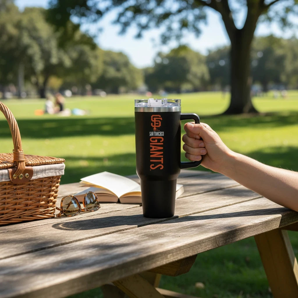 Coliseum Sports San Francisco Giants 40 oz black stainless steel travel tumbler with handle held at a park picnic
