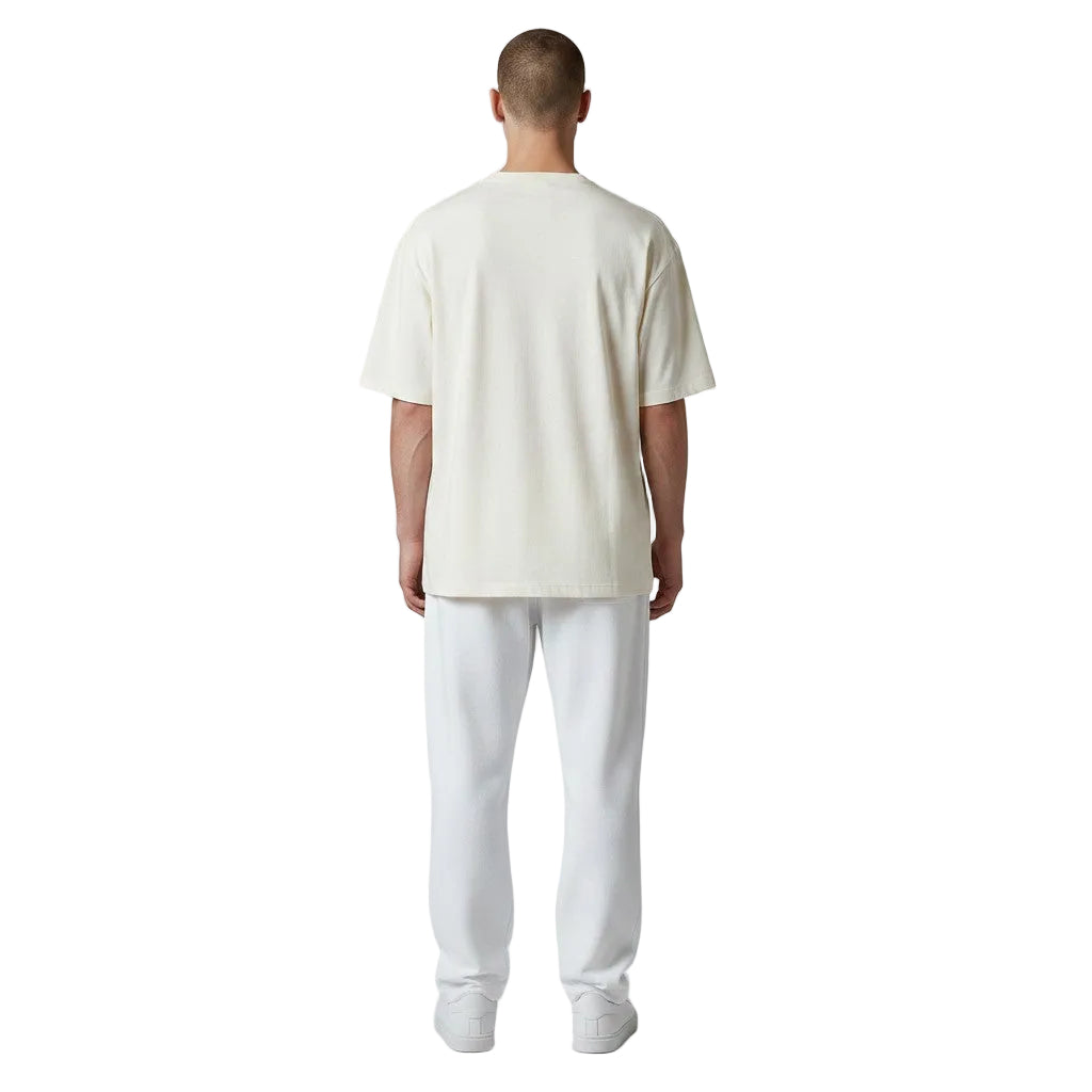Back view of a man wearing a cream-colored San Francisco Giants t-shirt and white sweatpants.